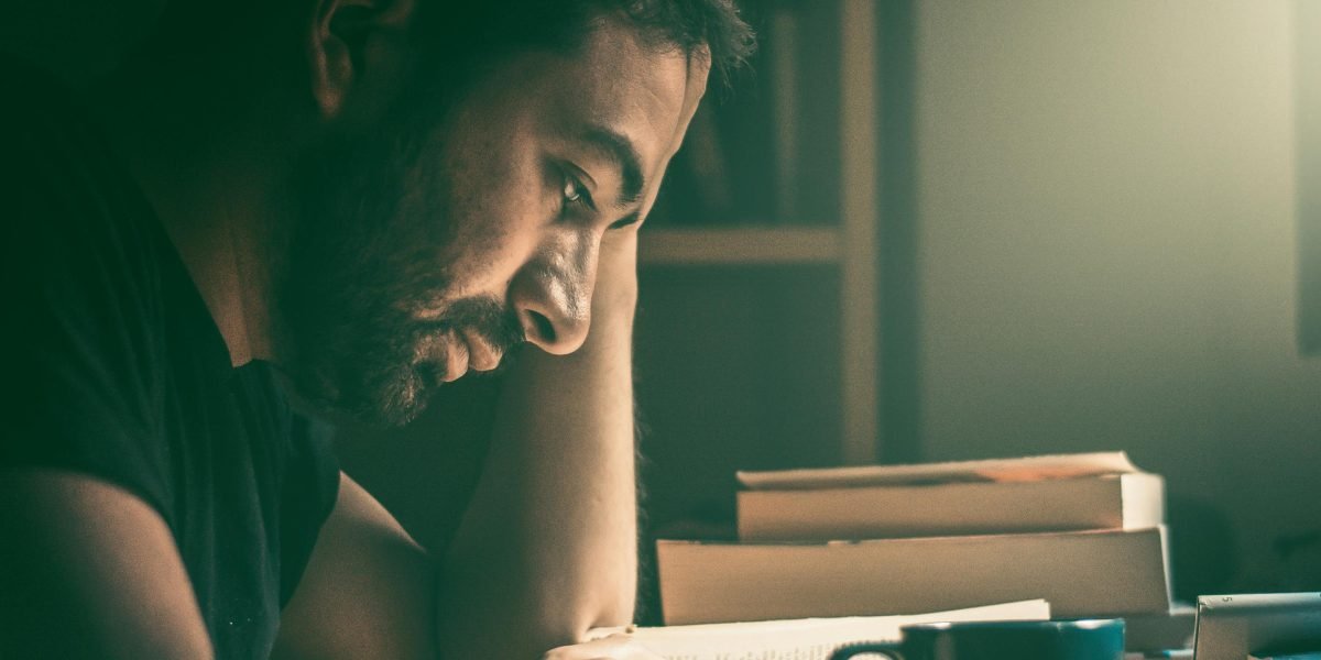 A reader immersed in a book, reflecting a range of emotions as the story unfolds.