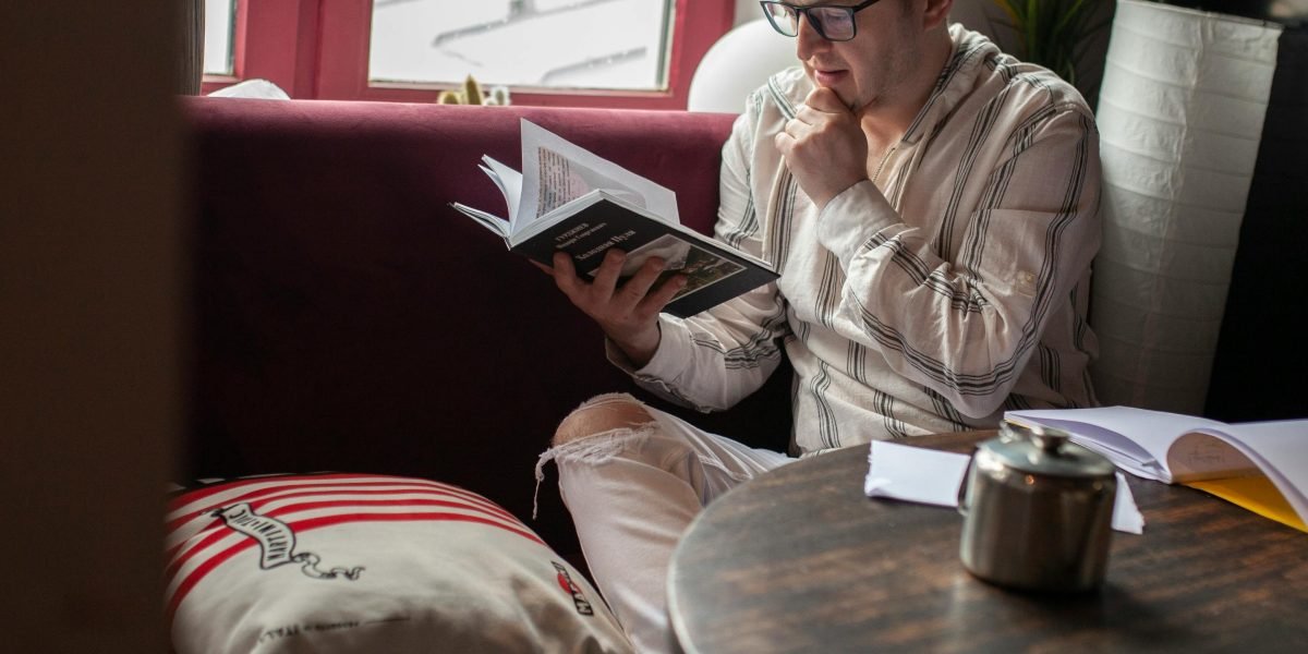 A reader pausing to reflect on the nuanced humor and emotional depth of a book.