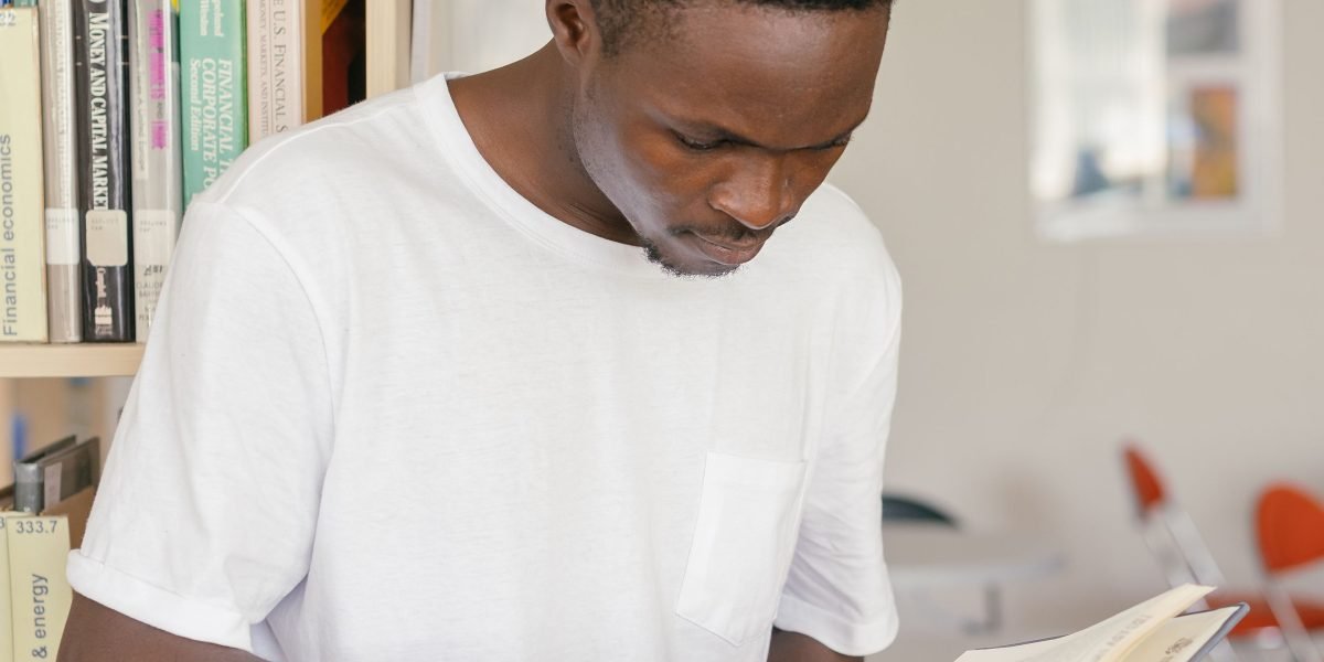 A person browsing a bookshelf, contemplating which classic novel to choose.