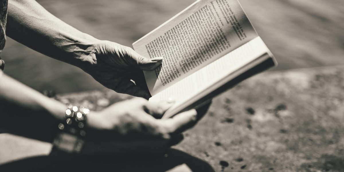 A person deeply absorbed in reading, pausing to reflect on the story's meaning.